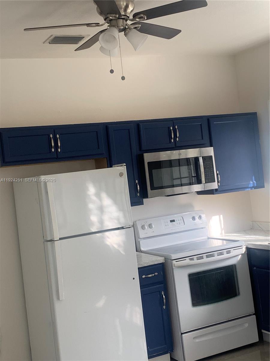 30900 Southwest 189th Avenue, Unit 2 Homestead, FL 33030 - Photo 2 of 7 a kitchen with stainless steel appliances a stove a microwave and a refrigerator