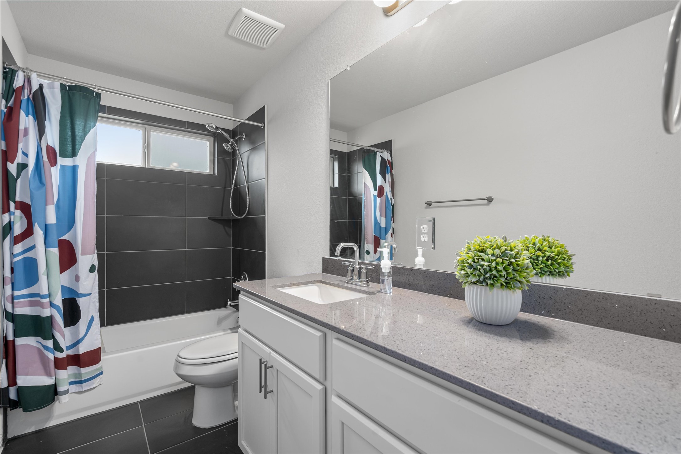 224 Backstays Loop Kyle, TX 78640 - Photo 15 of 19 Bathroom featuring a white vanity with integrated sink, a gray speckled countertop, and a large wall-mounted mirror