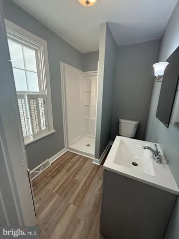 a bathroom with a sink a window and shower