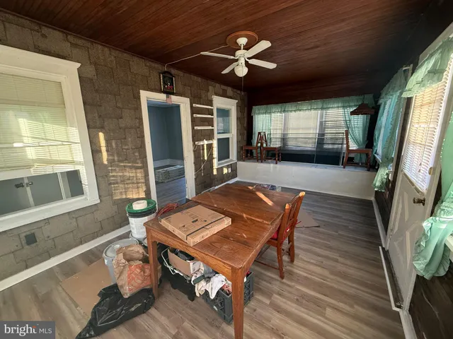 a living room with furniture a flat screen tv and floor to ceiling window