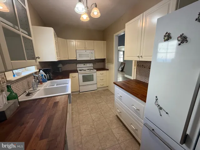a kitchen with granite countertop a stove a sink and a refrigerator