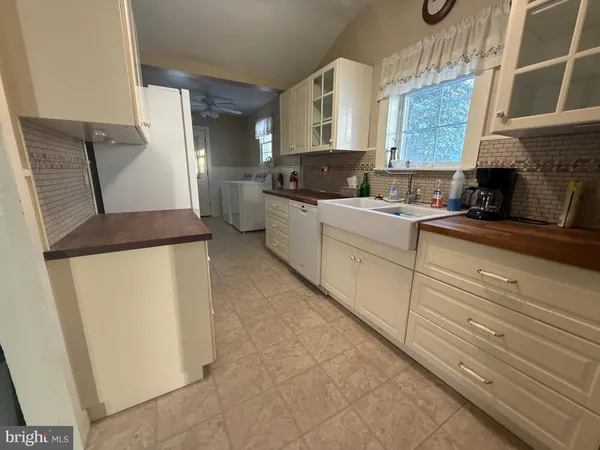 a kitchen with granite countertop white cabinets and white appliances