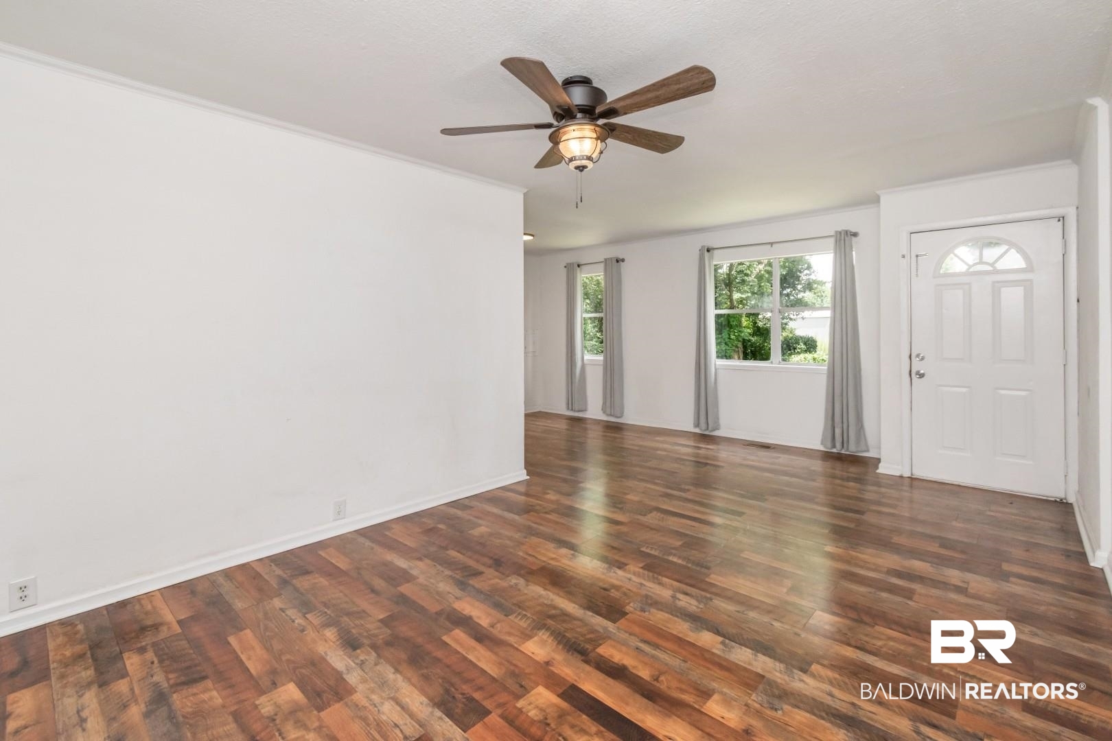 2905A McFarland Road, Unit F Mobile, AL 36695 - Photo 7 of 29 Spacious living area featuring wood-finish flooring, white walls, and a ceiling fan with integrated lighting