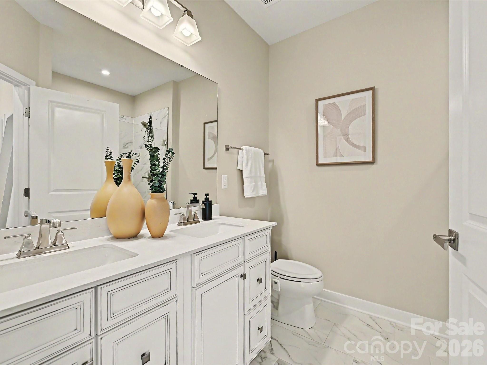 653 Uwharrie River Road Charlotte, NC 28211 - Photo 17 of 29 a bathroom with a double vanity sink toilet and a mirror