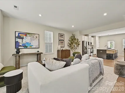 a living room with furniture a couch and paintings on the wall