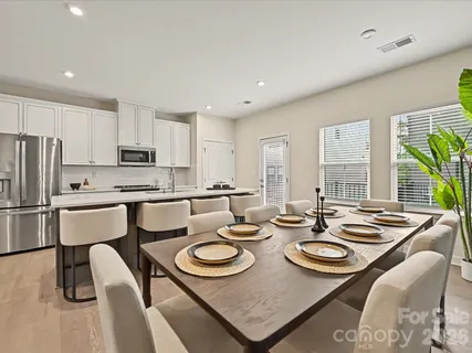 a dining room with furniture a rug and kitchen view