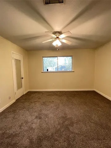 an empty room with a ceiling fan and a window