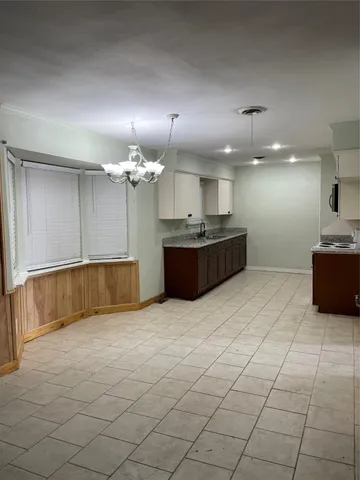 a large kitchen with kitchen island granite countertop a sink and a stove top oven