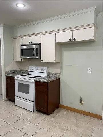 a kitchen with granite countertop white cabinets and stainless steel appliances