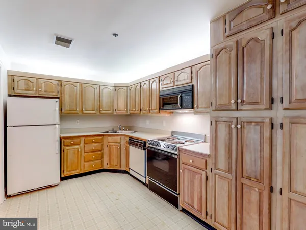 a kitchen with stainless steel appliances granite countertop a refrigerator a stove and a sink
