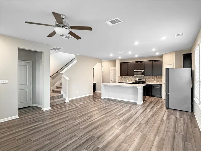 a kitchen with stainless steel appliances a refrigerator and a stove top oven