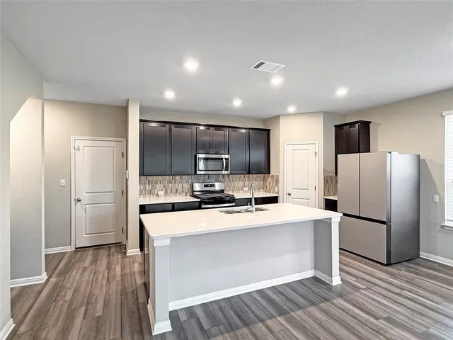 a kitchen with a sink a stove a refrigerator and cabinets