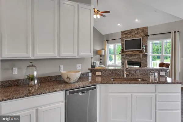 a kitchen with granite countertop a sink stainless steel appliances and cabinets