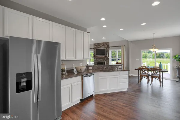 a kitchen with stainless steel appliances granite countertop a refrigerator stove microwave and white cabinets