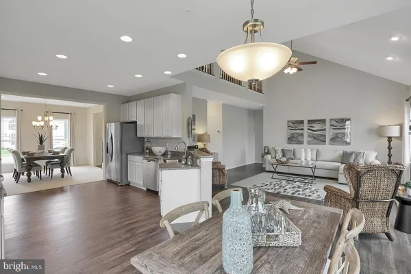 a living room with furniture and a dining table with wooden floor