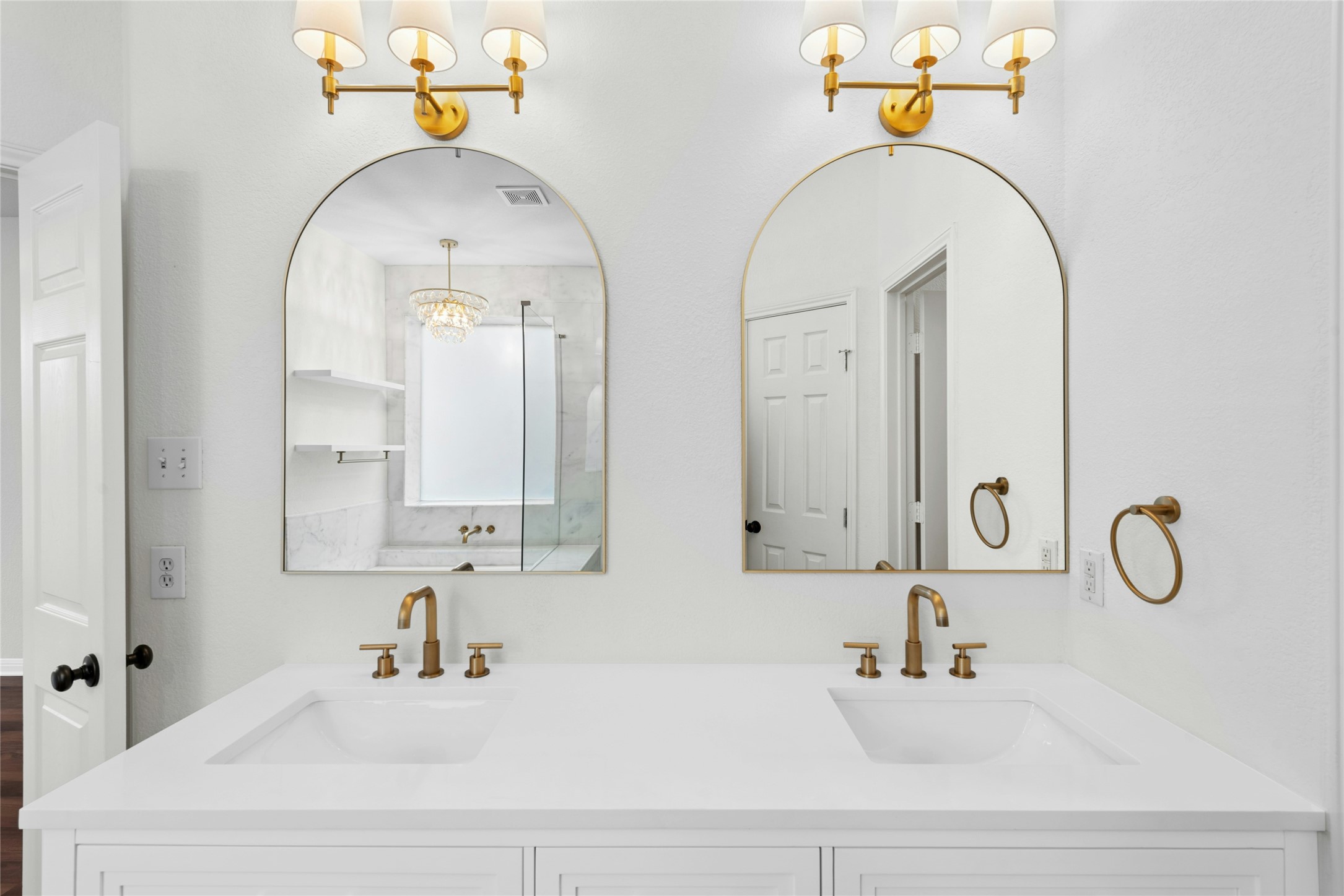 813 Caribou Ridge Trail Pflugerville, TX 78660 - Photo 28 of 39 Elegant dual vanity with quartz countertops, designer arched mirrors, and brushed-gold fixtures in the spa-inspired primary bathroom.