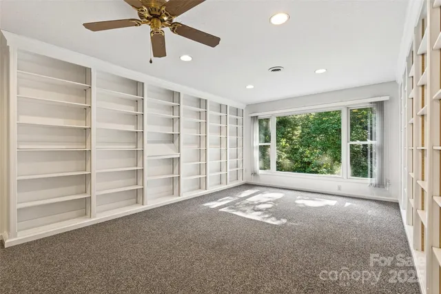 a view of an empty room with a cabinet and a large window