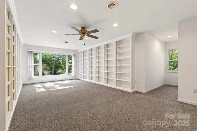 a view of an empty room with a fireplace and a window
