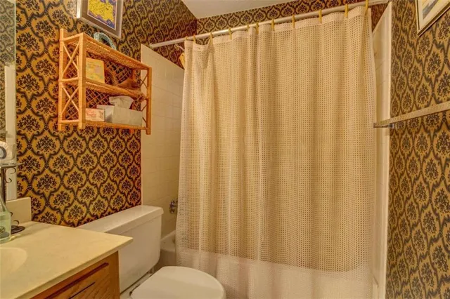 a bathroom with a toilet and a shower curtain