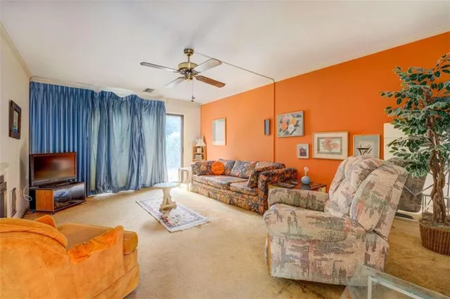 a living room with furniture ceiling fan and a flat screen tv