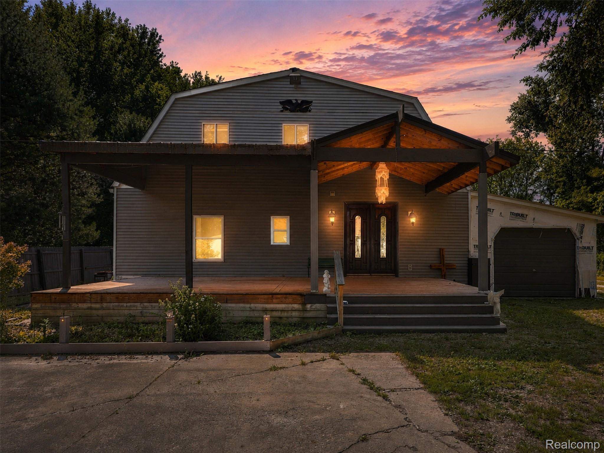 Barn-style architecture featuring gray siding and a prominent covered porch