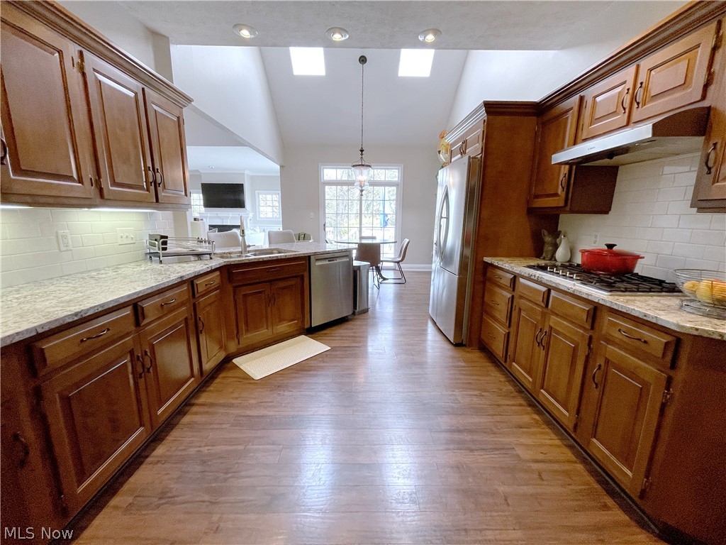 718 Sunridge Road Fairlawn, OH 44333 - Photo 6 of 49 Kitchen with stainless steel appliances, light granite countertops, tasteful backsplash, wood-type flooring, and hanging light fixtures