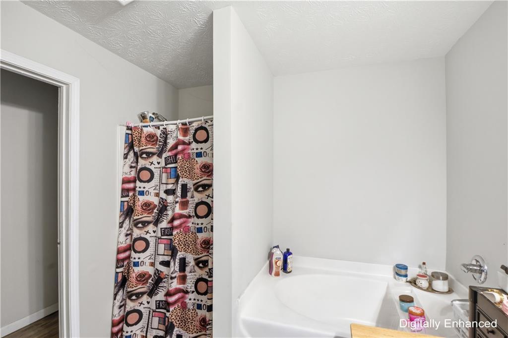 2555 Flat Shoals Road, Unit 2008 Atlanta, GA 30349 - Photo 25 of 33 a bathroom with a bathtub and a shower