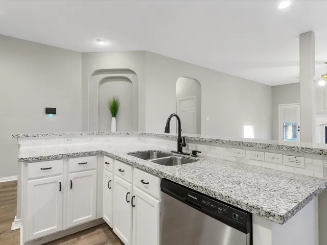 a kitchen with sink and mirror