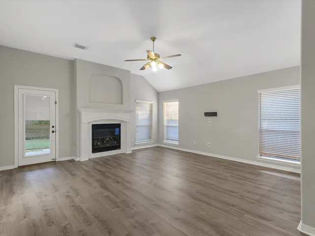 an empty room with windows and a fireplace