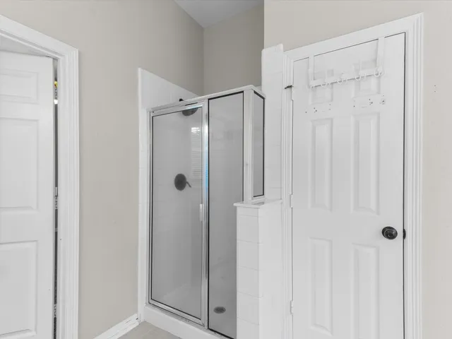 a bathroom with a shower and a glass door