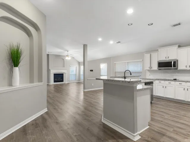 a kitchen with kitchen island white cabinets and refrigerator