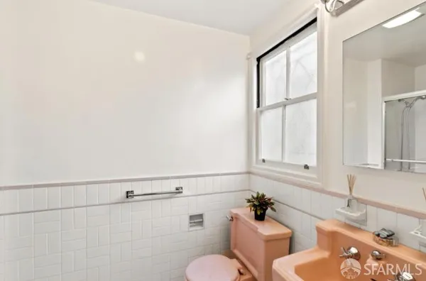 a bathroom with a sink mirror and toilet