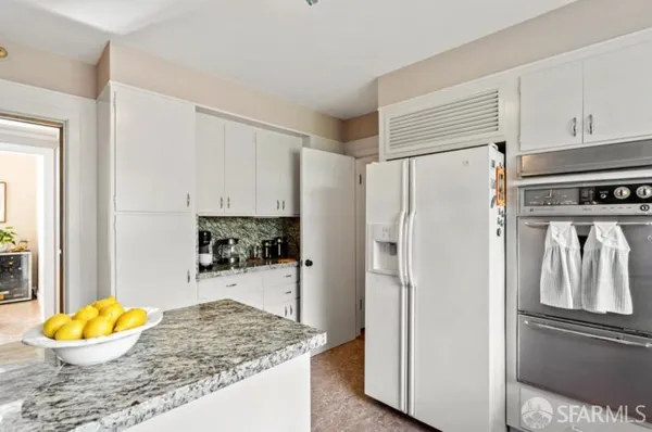a kitchen with stainless steel appliances granite countertop a refrigerator and a stove