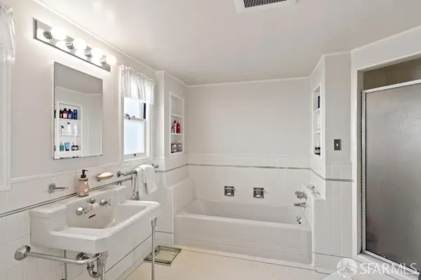 a bathroom with a bathtub a sink and mirror