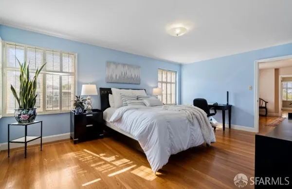 a bedroom with a bed and wooden floor