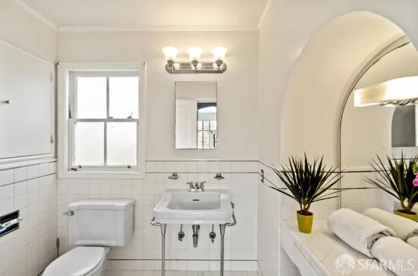 a bathroom with a sink a toilet and a mirror