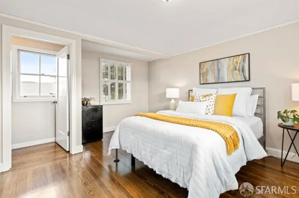 a bedroom with a bed and wooden floor