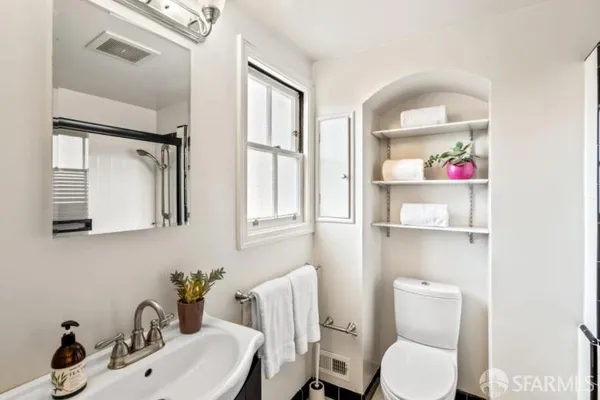 a bathroom with a toilet a sink and mirror