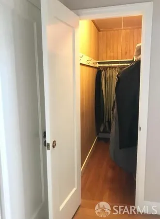 a view of walk in closet with clothes
