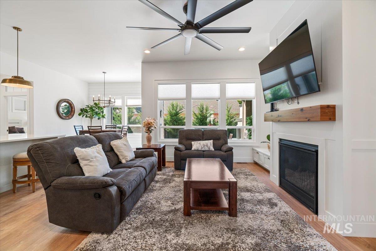 207 West Wrangler Street Meridian, ID 83646 - Photo 9 of 44 Living area featuring healthy amount of natural light, light wood-style floors, recessed lighting, a glass covered fireplace, and a ceiling fan
