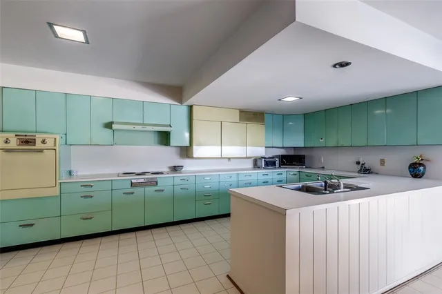 a kitchen with a sink a stove top oven and cabinets