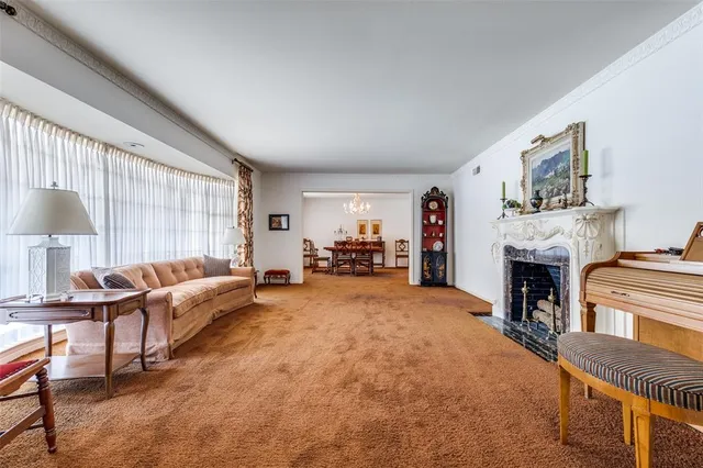 a living room with furniture a fireplace and a large window