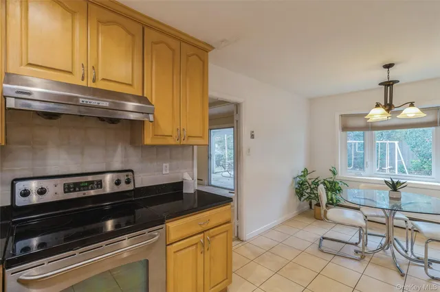 a kitchen with granite countertop cabinets and stove top oven