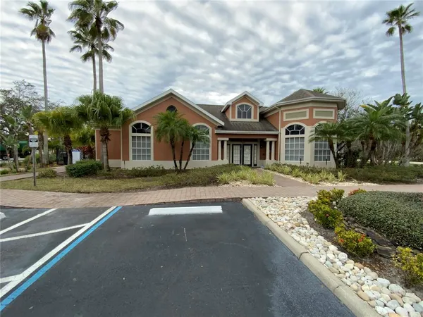 a front view of a house with a garden and trees