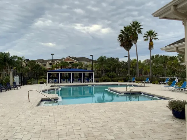 a view of a house with a swimming pool and sitting area