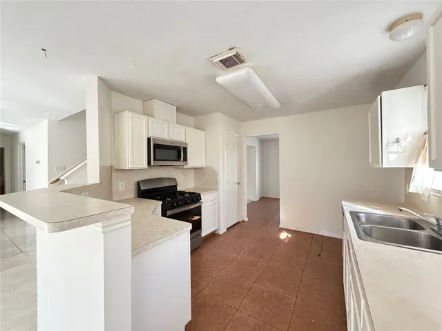 a kitchen with sink a microwave and cabinets