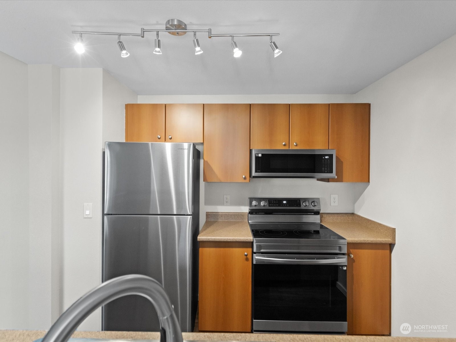 12404 East Gibson Road, Unit J303 Everett, WA 98204 - Photo 5 of 40 a kitchen with a refrigerator a stove and wooden cabinets