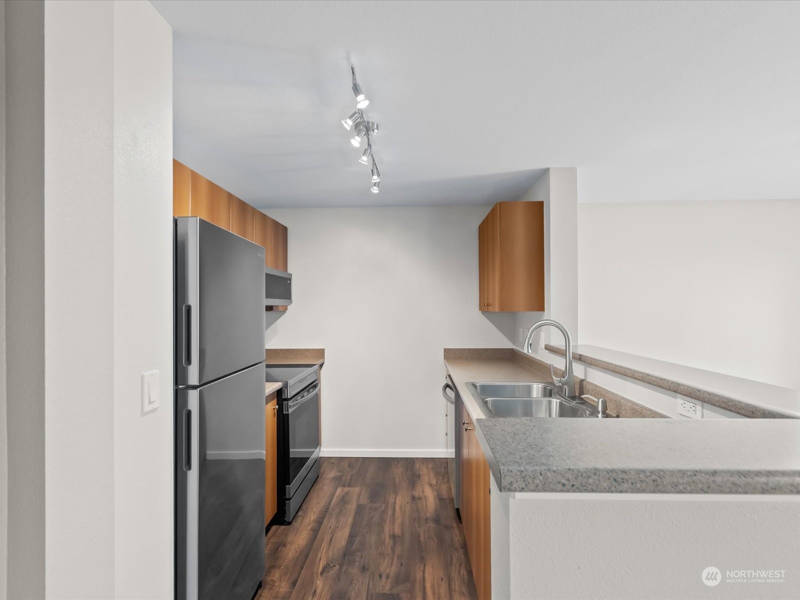 12404 East Gibson Road, Unit J303 Everett, WA 98204 - Photo 6 of 40 a kitchen with stainless steel appliances granite countertop a sink refrigerator and microwave