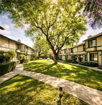 a view of a big yard with large trees and plants