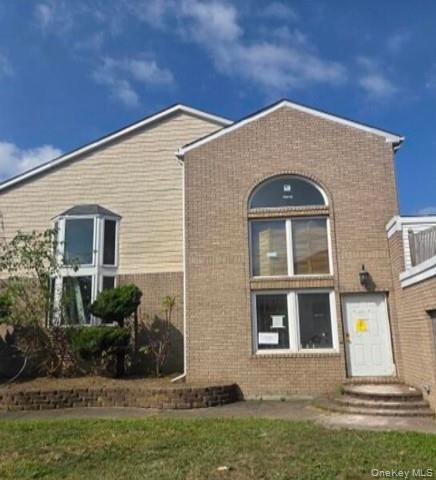 47 Monroe Street Inwood, NY 11096 - Photo 1 of 1 View of front facade featuring brick siding and a front lawn